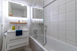 a white bathroom with a tub and a sink at Top möbliertes Apartment im Zentrum in Zwickau +21 photos