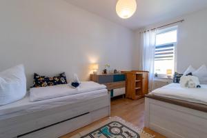 a bedroom with two beds and a desk and a window at Top möbliertes Apartment im Zentrum in Zwickau