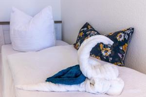 a white swan laying on a bed with a pillow at Top möbliertes Apartment im Zentrum in Zwickau