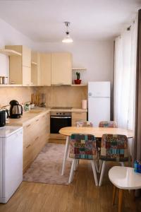 a kitchen with a table and a white refrigerator at Casa Centrale with Free Parking in Plovdiv +4 photos