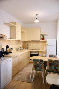 a kitchen with white cabinets and a table with chairs at Casa Centrale with Free Parking in Plovdiv