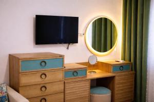 a bedroom with a dresser and a tv on a wall at Casa Centrale with Free Parking in Plovdiv