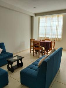 a living room with a blue couch and a table at Killitas home&apart in Cusco