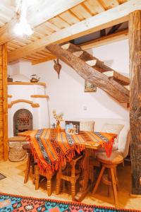 ein Esszimmer mit einem Holztisch und einem Kamin in der Unterkunft Casa Grosu in Preluca