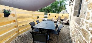 a patio with a table and chairs and a fence at la petite roche in Lanildut