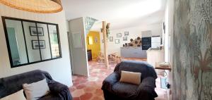 a living room with two chairs and a kitchen at la petite roche in Lanildut