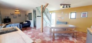 a living room with a table and a stair case at la petite roche in Lanildut