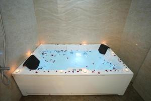 a hot tub with candles in a room at Elysia By THL-Near Westend Mall Aundh in Pune
