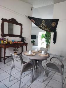 a dining room with a table and chairs and a mirror at Quarto privativo em casa compartilhada in Aracaju