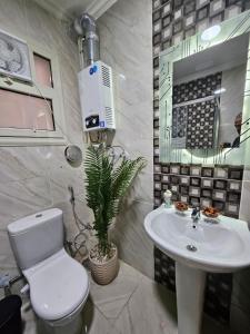 a bathroom with a white toilet and a sink at Elite 3 BR Apartment in Zayed in Sheikh Zayed +59 photos