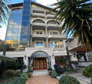 a large building with a red door and a palm tree at Broadway Boutique Hotel in Tirana