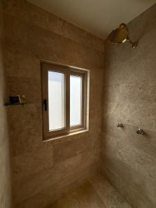 a bathroom with a window in the corner of a room at Cabañas San Antonio in Ezequiel Montes
