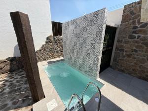 a swimming pool in a building with a stone wall at Cabañas San Antonio in Ezequiel Montes +58 photos