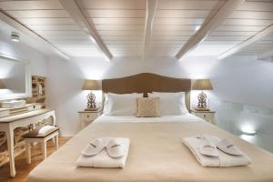 a bedroom with a large bed with towels on it at TOP SUITES in Ermoupoli
