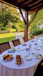 a white table with plates of food and wine glasses at Ostal Cassinia Maison d hôtes de charme avec petit déjeuner gourmand in Cassagne