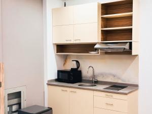 a kitchen with white cabinets and a sink at The Saj Hotel Apartments in Ras al Khaimah