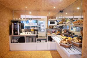 a kitchen with a bakery with food on display at Brit Hotel Le Surcouf in Saint Malo