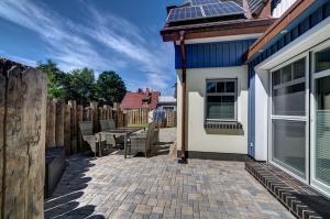 a patio with chairs and a table next to a house at Strandvej in Prerow