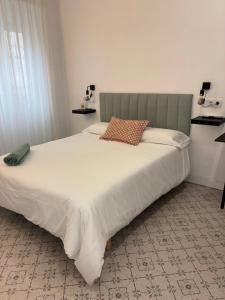 a bedroom with a large bed with a large white comforter at Hospédate con Teo in Abarán