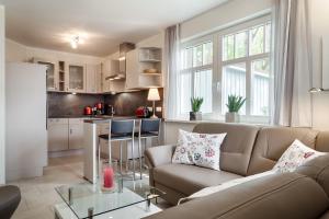 a living room with a couch and a kitchen at Deichblick in Prerow