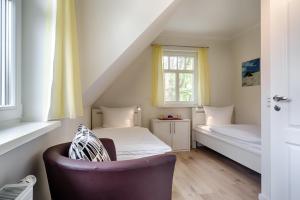 a small room with a bed and a chair at Deichblick in Prerow