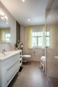 a bathroom with a sink and a toilet and a shower at Deichblick in Prerow +8 photos