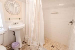 a white bathroom with a sink and a shower at Oceanfront Cottage - Steps from Short Sands Beach! in York +21 photos
