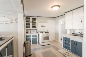 a kitchen with blue and white cabinets and appliances at Oceanfront Cottage - Steps from Short Sands Beach! in York