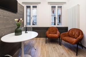 a room with two chairs and a table with a vase of flowers at Ca' Lumaga -Charming Holiday Studio in Chiavenna