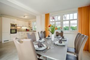a dining room with a white table and chairs at Dreimäderlhaus in Prerow +10 photos