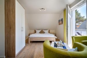 a bedroom with a bed and two chairs and a table at Dreimäderlhaus in Prerow