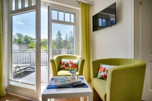 a living room with two chairs and a table and a window at Dreimäderlhaus in Prerow