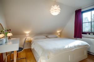 a bedroom with a bed and a desk and a window at Emma in Prerow