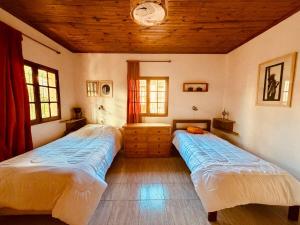 two beds in a room with a clock on the ceiling at Departamento céntrico in Esquel
