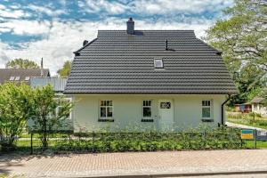a white house with a black roof at Stine in Prerow