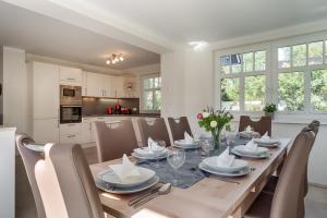 a dining room with a table and chairs and a kitchen at Stine in Prerow