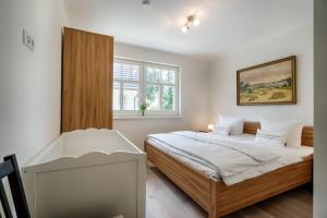 a white bedroom with a bed and a window at Stine in Prerow