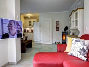 a living room with a red couch and a kitchen at Strandhus in Prerow