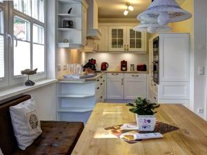 a kitchen with white cabinets and a wooden table at Strandhus in Prerow