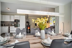 a dining room with a table with chairs and a vase of flowers at Strandzeit in Prerow