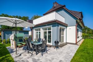 a patio with a table and chairs and an umbrella at Strandzeit in Prerow