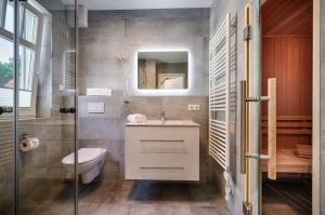 a bathroom with a toilet and a sink and a mirror at Strandzeit in Prerow +7 photos