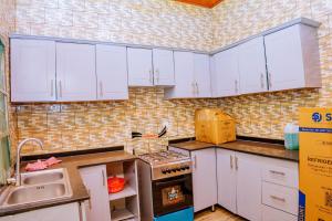 a kitchen with white cabinets and a stove and a sink at Antoine in Taba