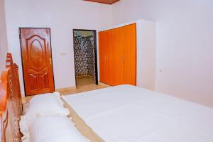 a bedroom with a bed and a wooden door at Antoine in Taba