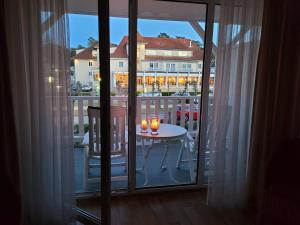 a room with a balcony with a table with candles at Haus Ostseeluft, Whg 4 Hühnergott in Baabe