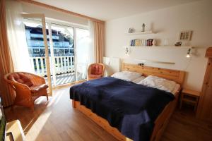 a bedroom with a bed and a balcony at Haus Ostseeluft, Whg 4 Hühnergott in Baabe