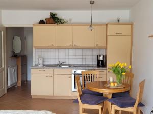 a kitchen with a table and a table and chairs at Haus Ostseeluft, Whg 4 Hühnergott in Baabe +3 photos