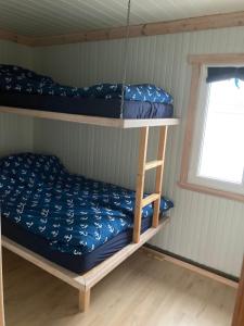 a bunk bed in a room with a window at Sætervika Floating home in Hosen