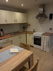 a kitchen with a table and a stove top oven at Sætervika Floating home in Hosen