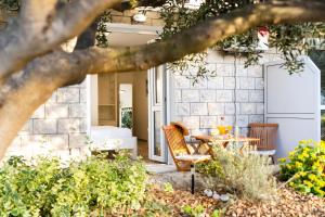 a patio with a table and chairs in front of a house at Guest House Kovacevic in Hvar